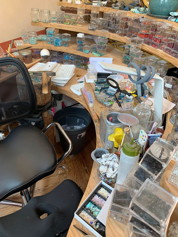 La place de travail de l'artiste avec beaucoup de boîtes contenant différents matériaux