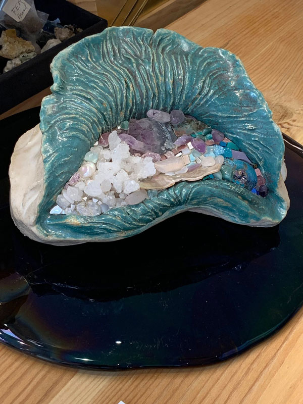Une œuvre représentant un grand coquillage rempli de mosaïques de différentes couleurs